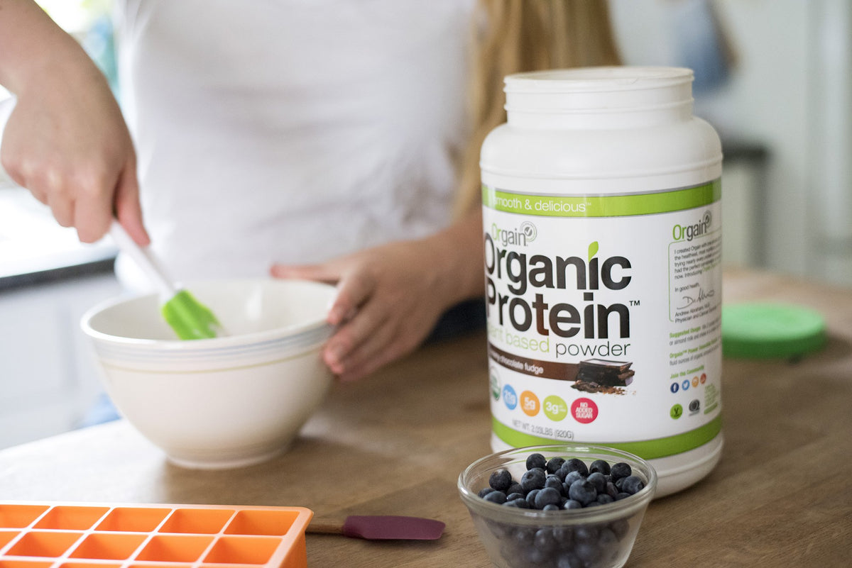 A woman making a recipe with Orgain's Organic Protein powder