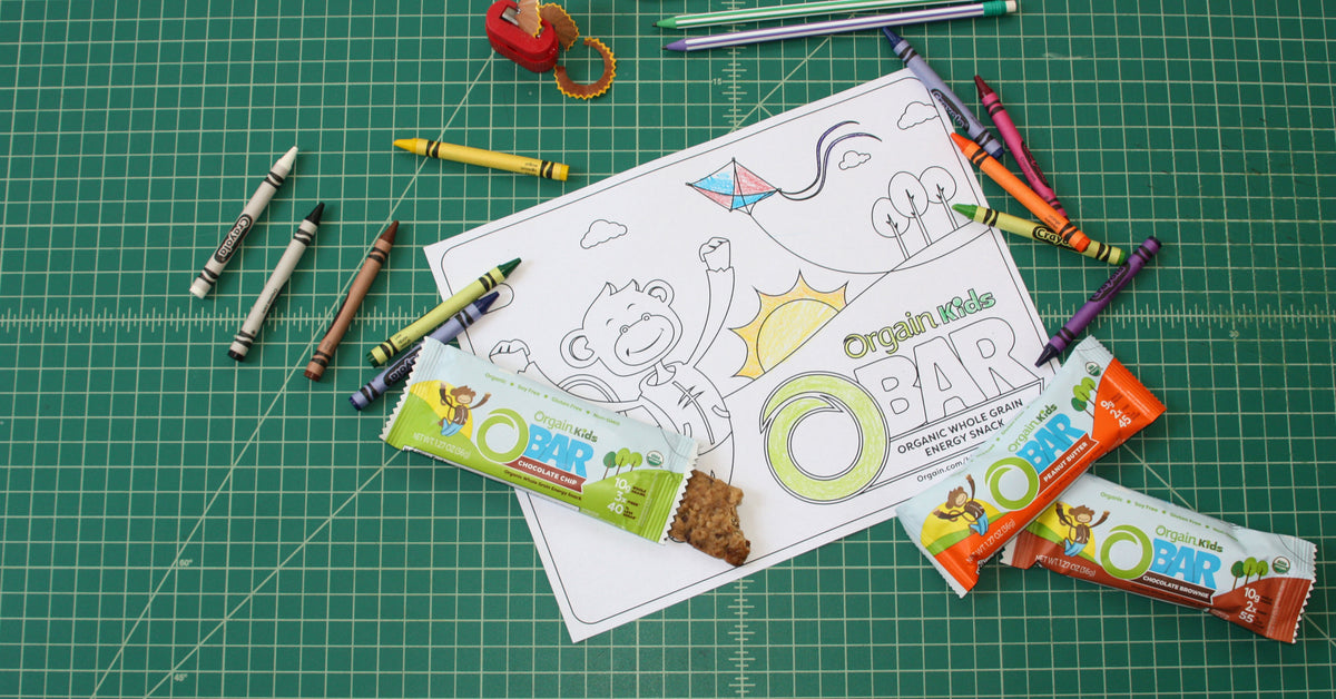 An Orgain Kids' Protein Bar sitting beside crayons on a coloring sheet