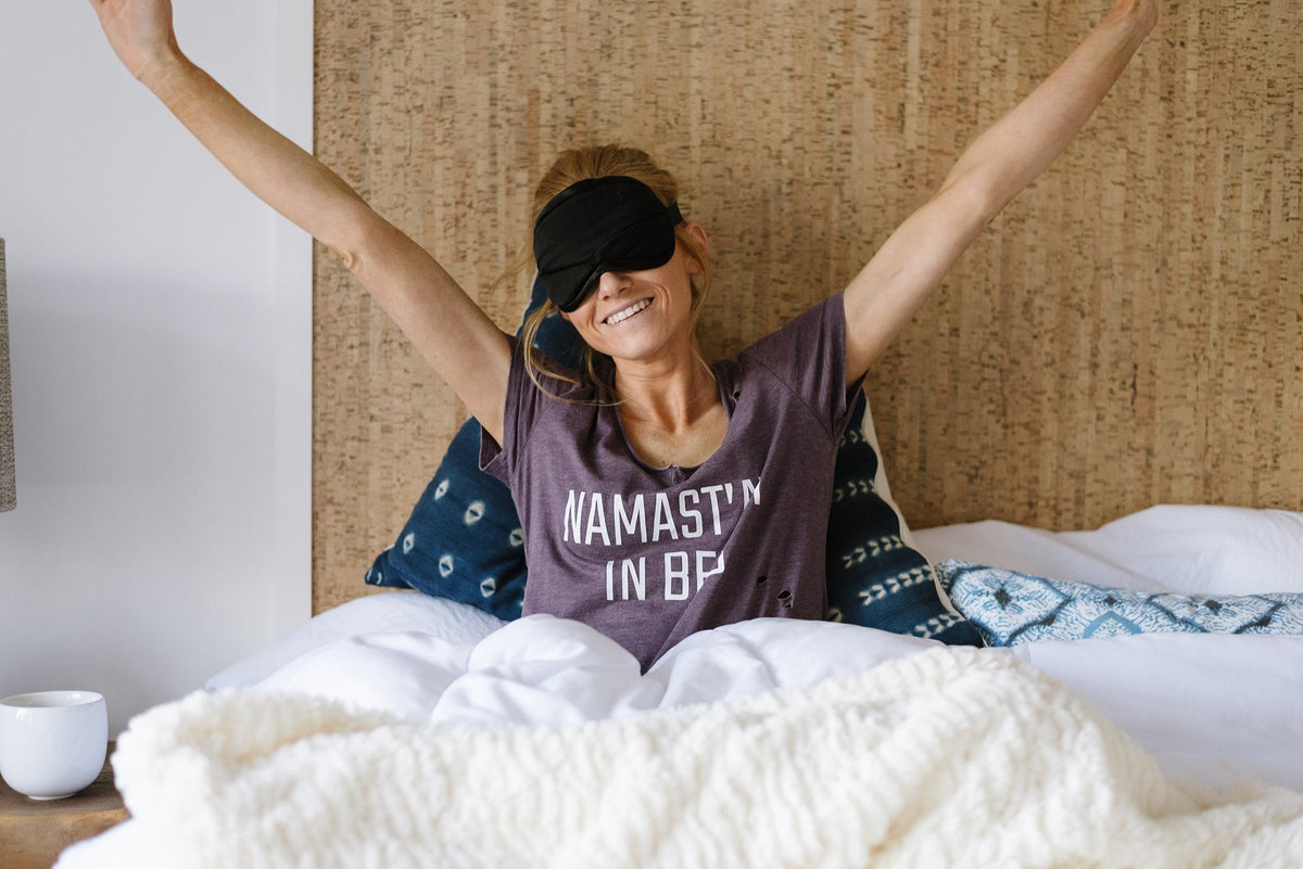 A refreshed woman waking up from a good, long night of sleep.