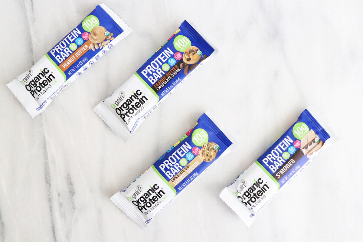 Four Organic Protein Bars in flavors Peanut Butter and S'mores, with 10g protein each, displayed against a white background.