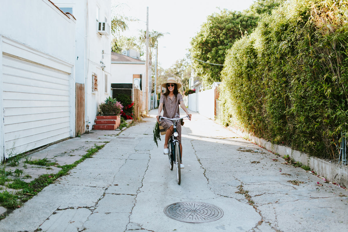 A happy woman going for a bike ride through the neighborhood on a sunny day.