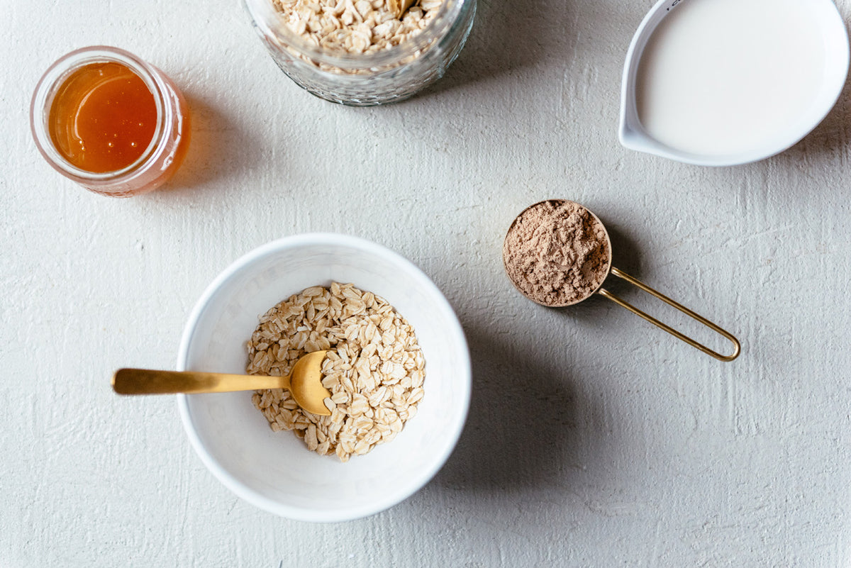 top down view of a bowl of oatmeal and a scoop of protein powder
