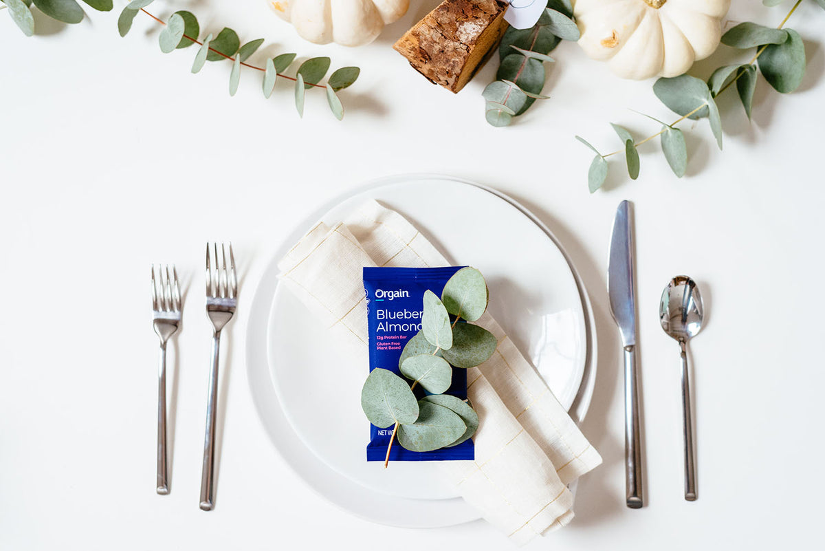 on orgain protein bar on a white plate next to silverware