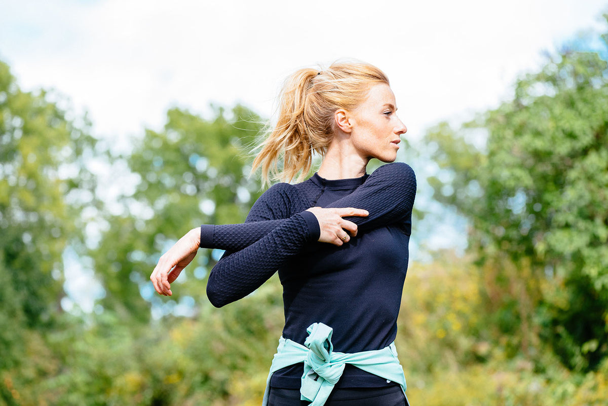 woman stretching her arms in the woods