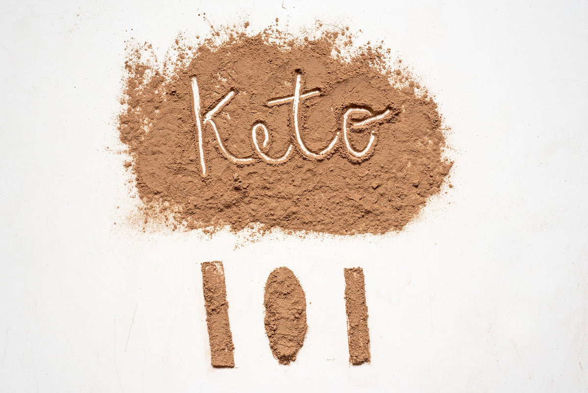 Light brown powder spread on a white surface with "Keto" written in it, and three vertical lines resembling "101" below.