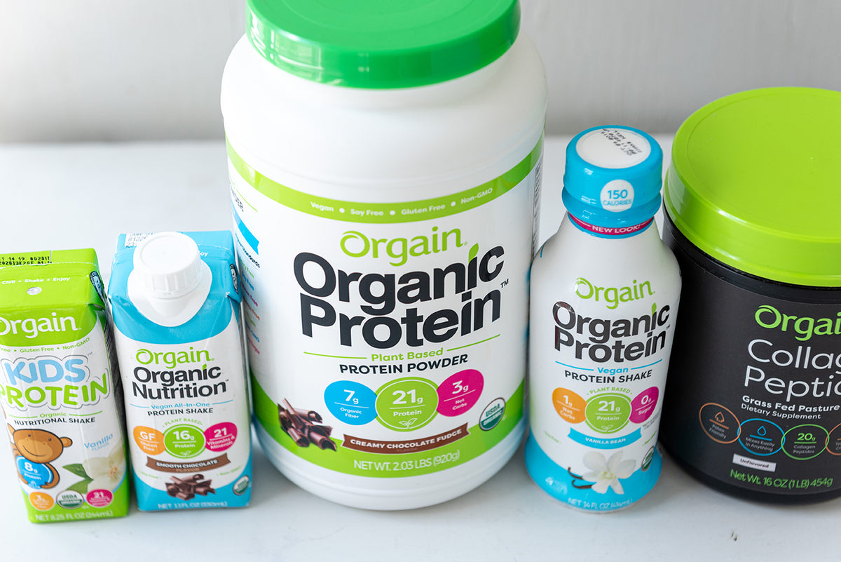 Various Orgain protein products, including powders, shakes, and bars, displayed on a shelf.