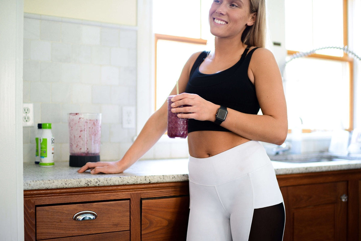 A happy Orgain customer enjoying the smoothie she just made.