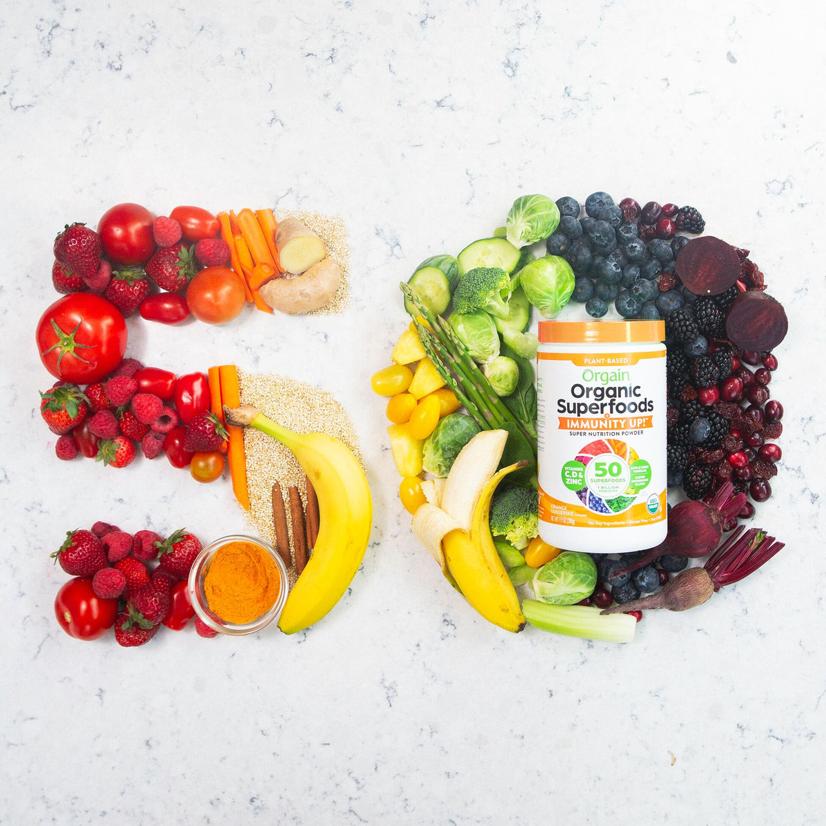 A variety of fruits and vegetables are arranged to form the number 50 on a marble surface. To the right, a container of Orgain Organic Superfoods powder is placed, surrounded by more fruits and vegetables, demonstrating the product's natural ingredients.