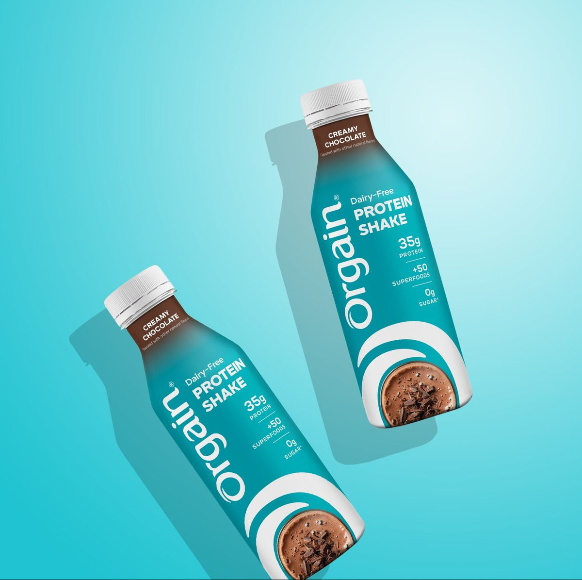 Two bottles of Organ Protein Shake in chocolate flavor, arranged diagonally on a bright cyan gradient background with soft drop shadows.